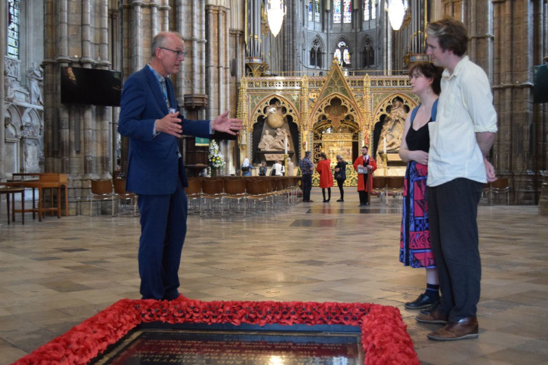 Blue Badge Tourist Guide Alex Hetherington with visitors at grave of The Unknown Warrior, Westminster Abbey in London © APTG